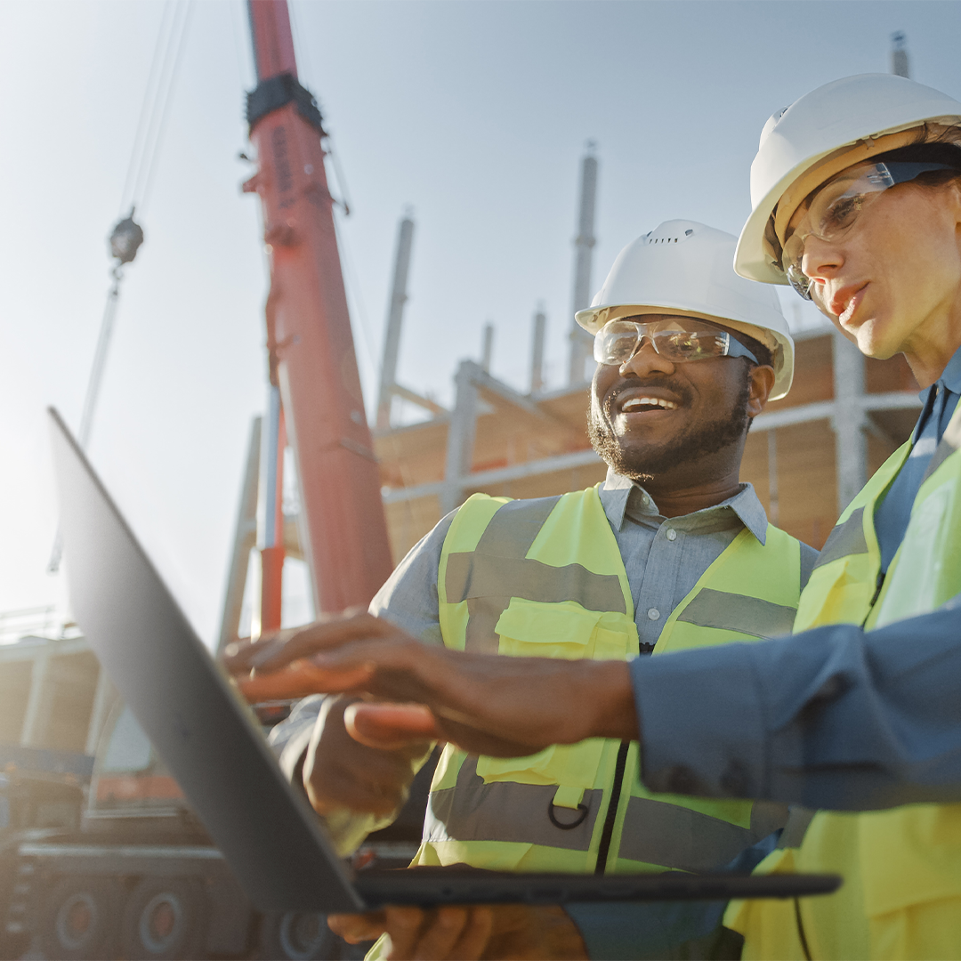 Work in any environment Two construction workers are checking something on the ASUS ExpertBook laptop at a construction field.