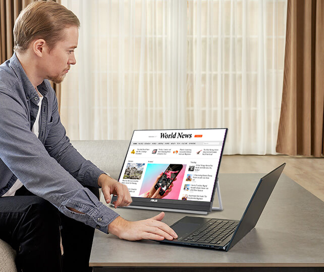 Side view of a man works from home using ZenScreen MB229CF in kickstand mode at lower cafe table