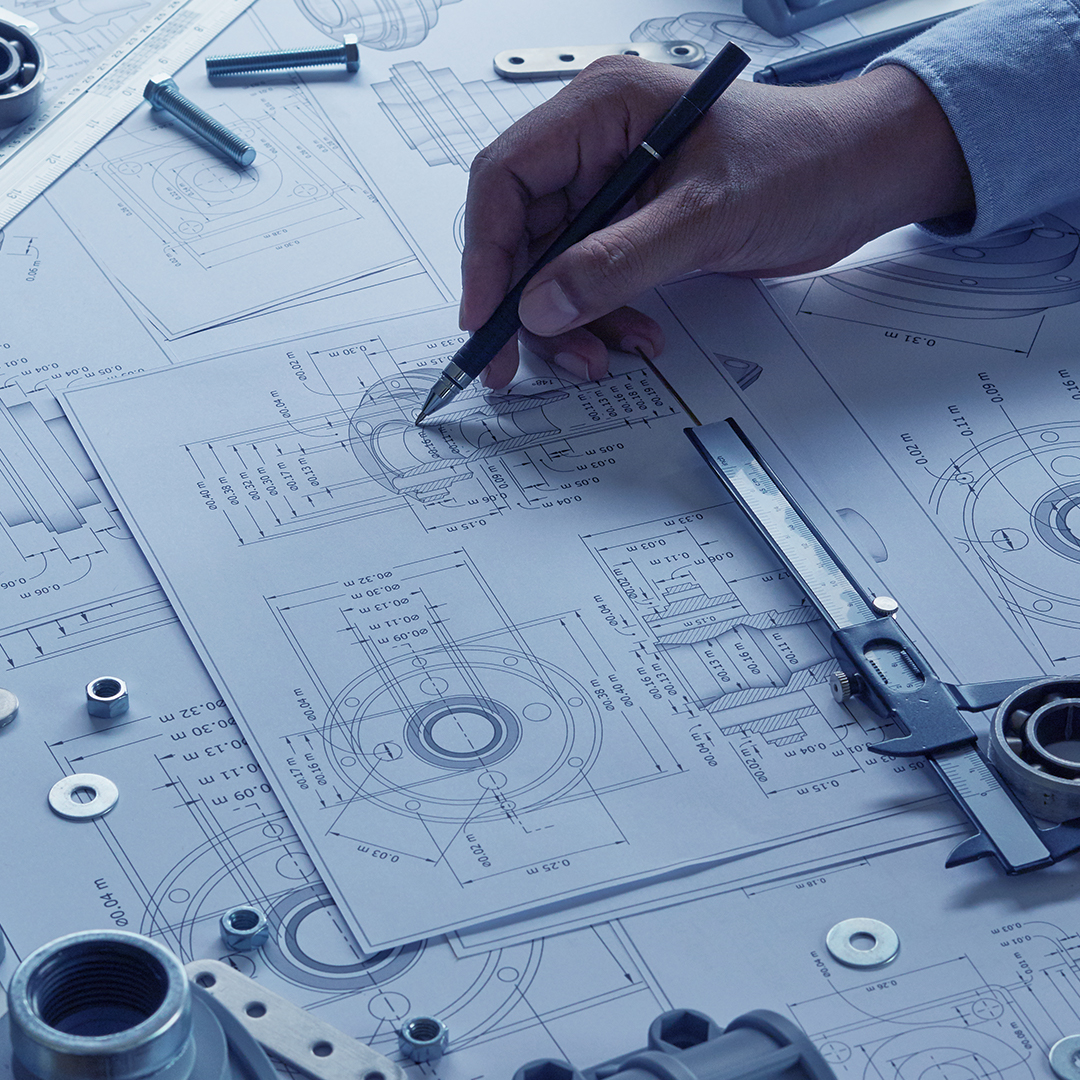 Scalable solutions for engineers Engineer technician designing draws mechanical parts in a factory. Project blueprints and measuring bearings caliper tools are on the table.